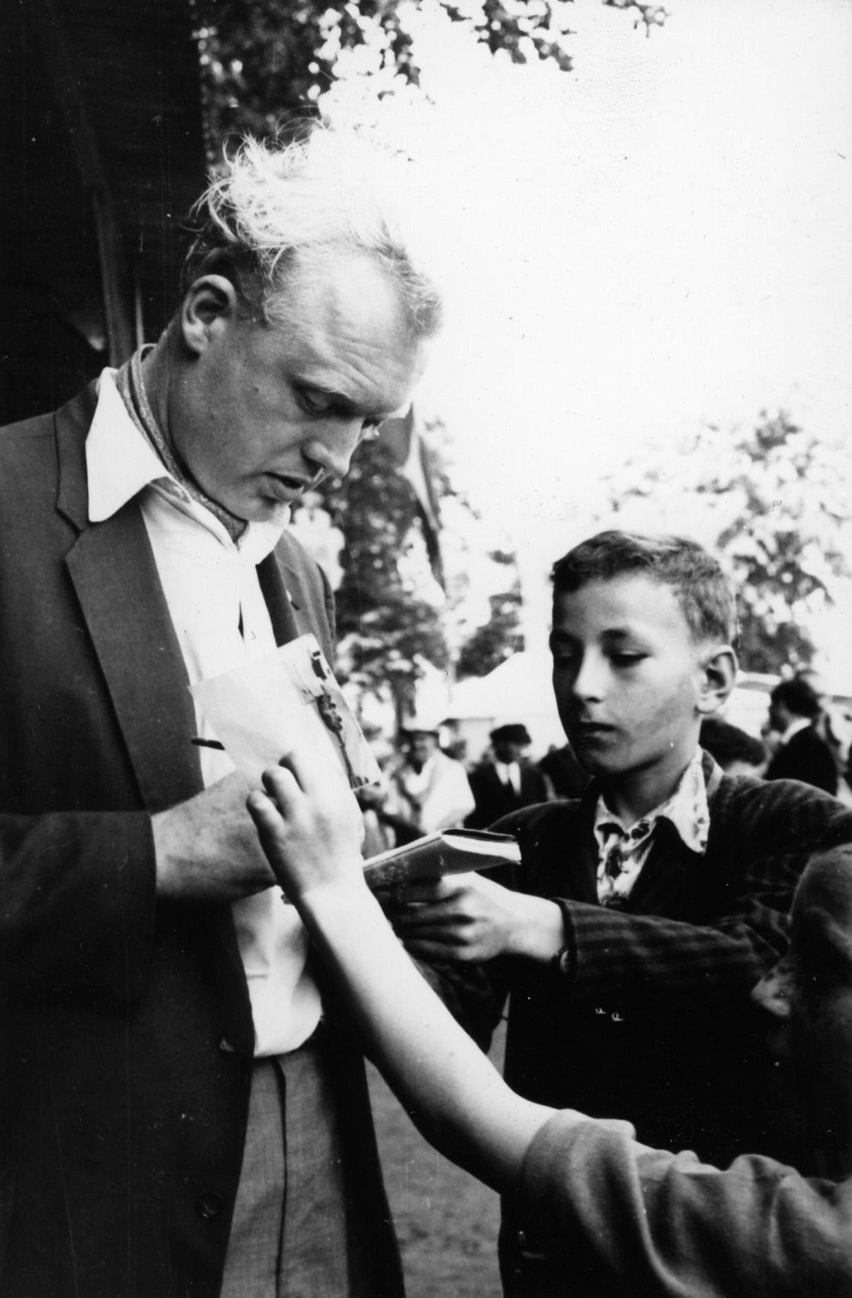 Mike Hawthorn was recognised for his speed, but also for his attire: here in a green jacket, white shirt and bow tie signing autographs at the 1955 24 Hours of Le Mans.